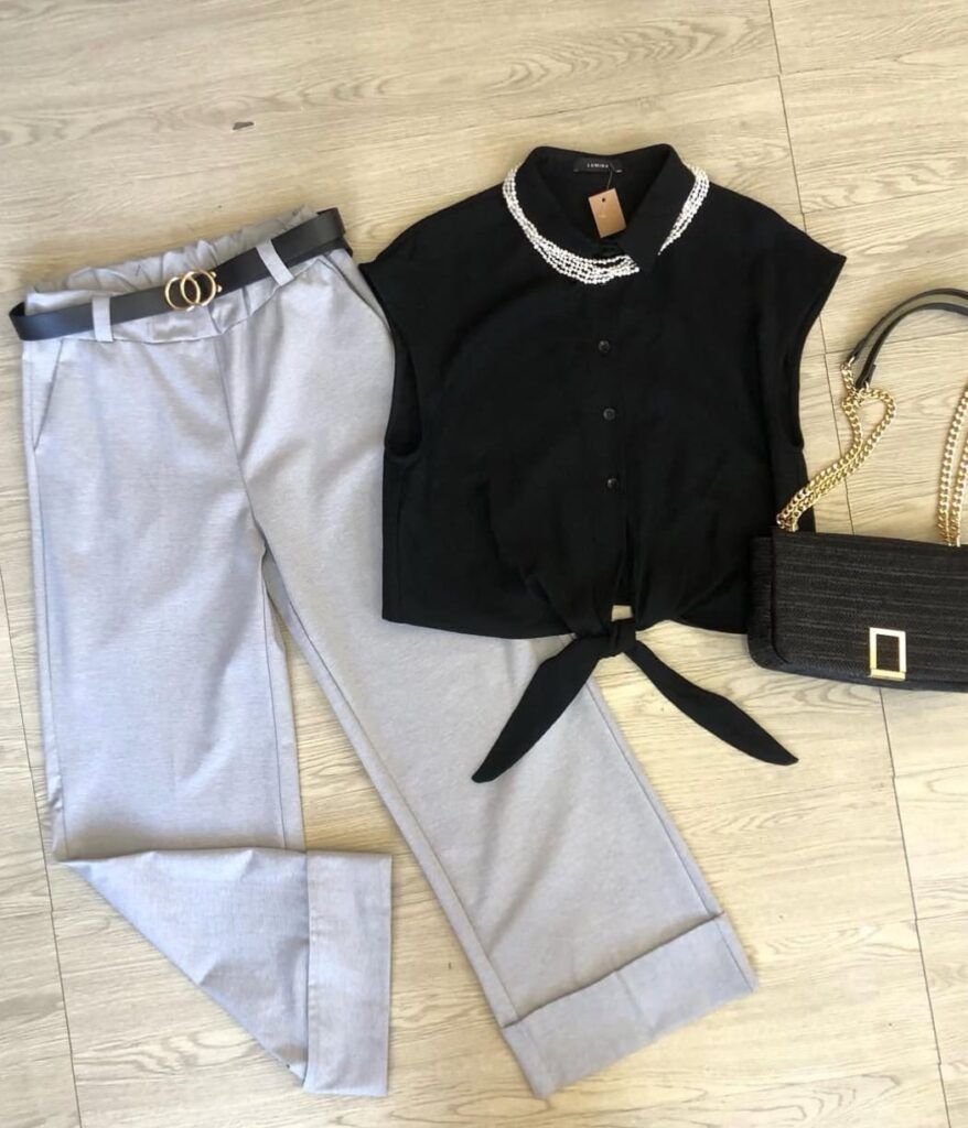 Pantalón gris claro con cinturón negro, blusa negra y bolso negro y dorado de Modas Susana